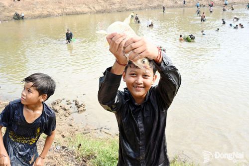 Niềm vui mừng của những người bắt được cá to tại lễ hội. Ảnh: Nguyễn Tấn
