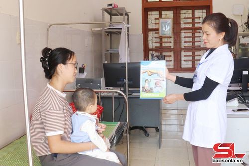 Cán bộ Trạm Y tế xã Chiềng Lao tuyên truyền về tiêm vắc xin phòng bệnh cho trẻ.