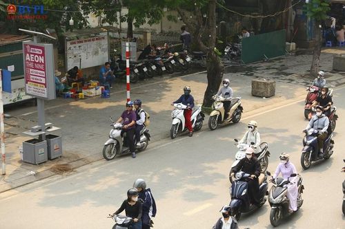 Nhiều người chọn trú dưới bóng cây để chờ đèn đỏ.