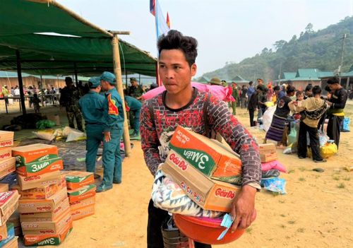Một người dân cụm bản Kà Lừm mang tặng phẩm trở về sau buổi đón Tết Bunpimay. Ảnh: SONG NGUYÊN