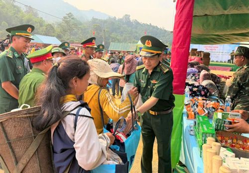 Đại tá Hoàng Văn Mẫn, Chính ủy Bộ đội Biên phòng thành phố Đà Nẵng (phải) hỗ trợ người dân cụm bản Lào sắp xếp quà tặng. Ảnh: SONG NGUYÊN