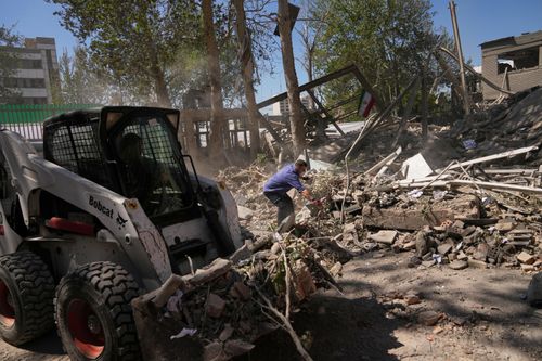Các công nhân dọn dẹp đống đổ nát tại khu phức hợp Đại học Công nghệ Sharif ở Tehran, sau khi trúng bom trong một cuộc không kích của Mỹ và Israel. (Ảnh: AP)