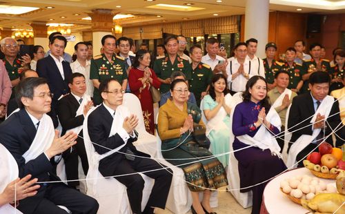 Các đại biểu thực hiện nghi thức buộc chỉ cổ tay truyền thống cầu bình an, may mắn và sức khỏe. Ảnh: Bộ Ngoại giao