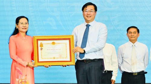 Phó Bí thư Thường trực Thành ủy TPHCM Lê Quốc Phong trao Huân chương Độc lập hạng ba đến đồng chí Nguyễn Thị Lệ, nguyên Phó Bí thư Thành ủy, nguyên Chủ tịch HĐND TPHCM. Ảnh: VIỆT DŨNG