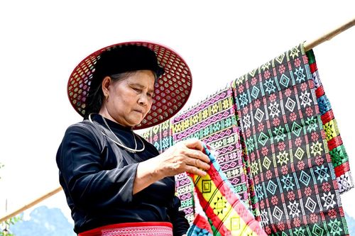 Trời nắng người dân tranh thủ phơi đồ và không quên đội nón che đầu giữa thời tiết nắng nóng.
