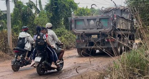 Người dân đón con em đi trên cung đường xấu và hẹp, cùng hàng loạt xe ô tô tải trọng lớn thường xuyên chạy trên đường.