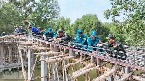 Cán bộ, chiến sĩ lực lượng vũ trang xã Hòn Đất hỗ trợ người dân xây dựng cầu dịp Tết quân-dân mừng Chôl Chnăm Thmây năm 2026.