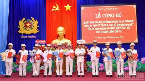 Đại tá Hồ Việt Triều, Bí thư Đảng ủy, Giám đốc Công an tỉnh Cà Mau (giữa) trao quyết định, tặng hoa chúc mừng các đồng chí Trưởng Công an xã/phường sau khi hợp nhất tỉnh.