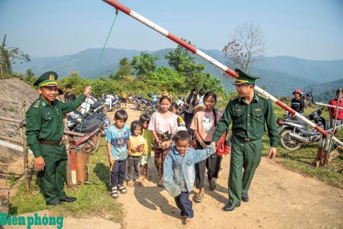 Bộ đội Biên phòng đón các cháu nhỏ ở bản Sê Sáp sang vui Tết Bunpimay. Ảnh: Lê Văn Chương