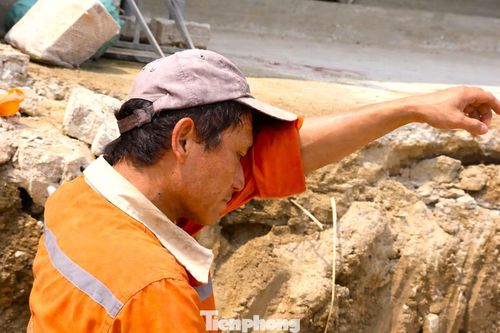 Anh Nguyễn Khắc Quân (trú xã Đô Lương, Nghệ An) đang thi công hạng mục cống thoát nước tại công trường. Dù phải đứng làm việc dưới nước, cái nóng hầm hập từ mặt đường và hơi nóng từ trên cao khiến sức nóng gần như không giảm bớt. Kéo vạt áo lau mồ hôi trên gương mặt đỏ bừng, anh Quân nói: “Mấy ngày nay nắng nóng khủng khiếp, người lúc nào cũng đổ mồ hôi như tắm. Chúng tôi phải làm việc sớm hơn và kết thúc muộn hơn để tránh nắng”.