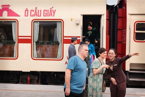 Nhân viên phục vụ hướng dẫn và giới thiệu cho du khách quốc tế về hành trình “Tàu 5 cửa ô".
