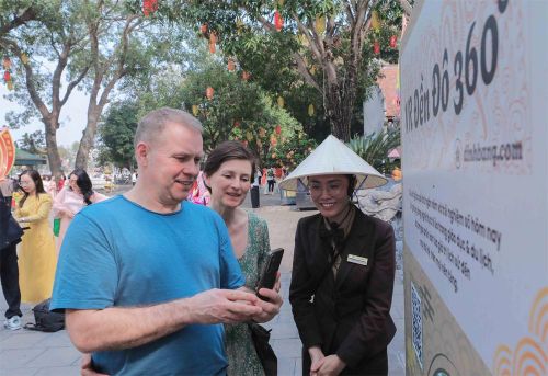 Du khách quốc tế trải nghiệm quét mã QR để tìm hiểu thông tin điểm đến, một điểm nhấn trong ứng dụng chuyển đổi số vào du lịch.