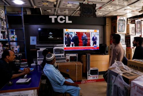 Người dân xem tin tức trên màn hình tivi tại một cửa hàng ở Hyderabad, Pakistan. Ảnh: The Guardian