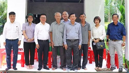 Tổng Biên tập Báo Nhân Dân Lê Quốc Minh chụp hình lưu niệm với gia đình được trao nhà Đại đoàn kết.
