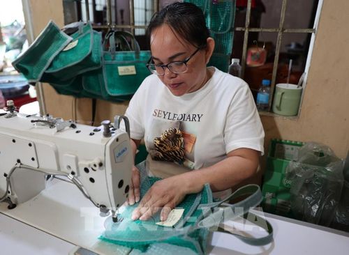Bà Trần Thị Mỹ, ngụ xã Long Sơn, có thu nhập ổn định khoảng 200.000 đồng/ngày nhờ làm túi lưới. Ảnh: Hoàng Nhị – TTXVN