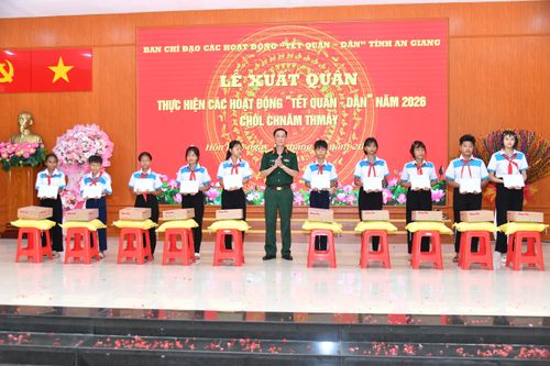Đại tá Cao Minh Tâm – Phó Chính ủy Bộ Chỉ huy Quân sự tỉnh An Giang trao tặng học bổng cho trẻ em nghèo vượt khó học tốt tại lễ xuất quân Tết Quân - Dân