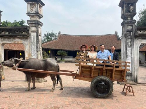 Du khách thích thú trải nghiệm xe trâu ở làng cổ Đường Lâm. Ảnh minh họa
