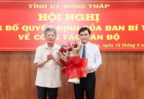 Bí thư Tỉnh ủy Ngô Chí Cường trao quyết định và tặng hoa chúc mừng ông Nguyễn Văn Mười. Ảnh: Cổng TTĐT Đồng Tháp
