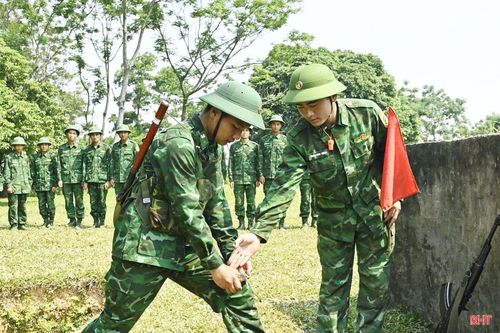 Thiếu úy Trần Anh Thao hướng dẫn chiến sĩ mới thực hành động tác ném lựu đạn.
