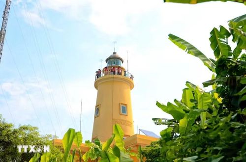 Du khách thích thú ngắm toàn cảnh đảo Cồn Cỏ từ đỉnh Hải Đăng, nơi có tầm nhìn bao quát giữa trùng khơi. (Ảnh: Nguyên Linh/TTXVN)