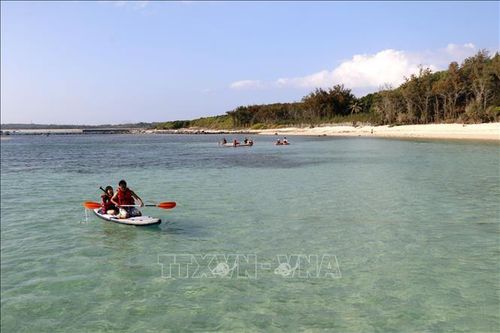Du khách chèo SUP ở đảo Hòn Tranh, gần đặc khu Phú Quý (tỉnh Lâm Đồng).
