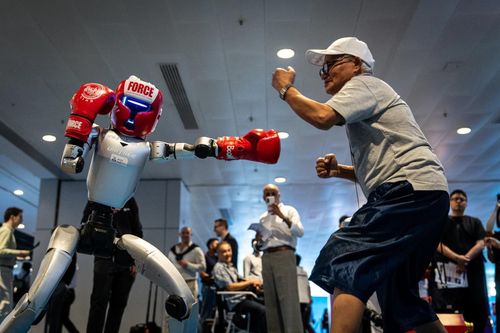 Một robot hình người của Unitree Robotics đeo găng boxing đối đầu cùng khách tham quan. (Nguồn: Chan Long Hei)
