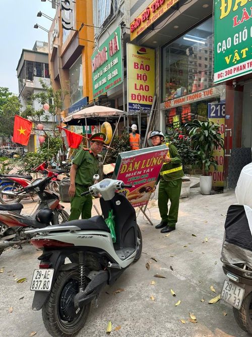 Tháo dỡ biển quảng cáo sai quy định trên đường Phan Trọng Tuệ. Ảnh: Kim Xuyến.