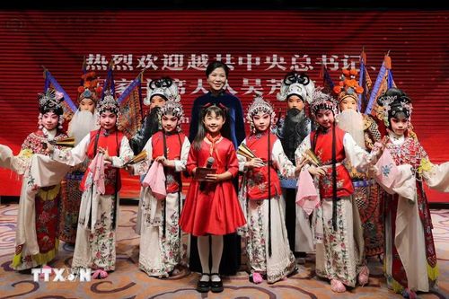 Phu nhân Ngô Phương Ly với các học viên của trung tâm biểu diễn tiết mục “Mộc Quế Anh quải soái” chào mừng. (Ảnh: TTXVN)