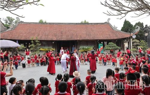 Học sinh trải nghiệm Hát Xoan cùng các thành viên Câu lạc bộ Hát Xoan và dân ca Hùng Lô tại đình Hùng Lô.