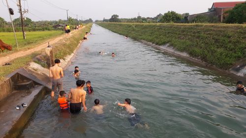 Nhiều trẻ em lựa chọn tắm và tập bơi trên các con kênh của quê hương - Ảnh: N.V