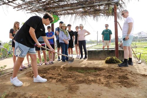 Khách du lịch trải nghiệm cuốc đất trồng rau tại Làng rau Trà Quế
