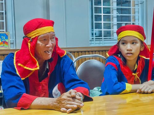 Ông Nguyễn Văn Hảo (bên trái) chỉ dạy cách hát cho các em.