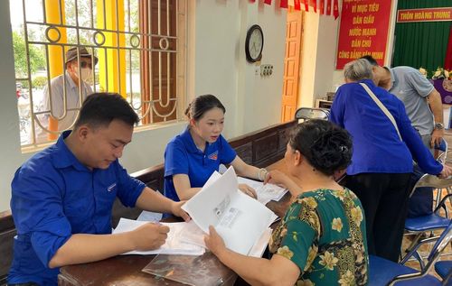 Thanh niên hỗ trợ người dân kê khai nhân khẩu phục vụ công tác giải phóng mặt bằng. Ảnh: DH.