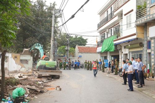Lực lượng chức năng tổ chức cưỡng chế, tháo dỡ các ki ốt vi phạm tại ao đình thôn Dương Đá. Ảnh: Hoàng Anh