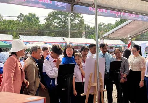 Bà Huỳnh Thị Anh Thảo, Phó Giám đốc Sở Văn hóa, Thể thao và Du lịch Gia Lai (áo xanh) cùng các đại biểu, học sinh tham quan các gian hàng.
