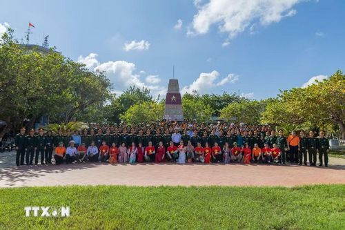 Đoàn công tác chụp ảnh lưu niệm trước cột mốc chủ quyền tại đảo Trường Sa. (Ảnh: Xuân Quý/TTXVN)
