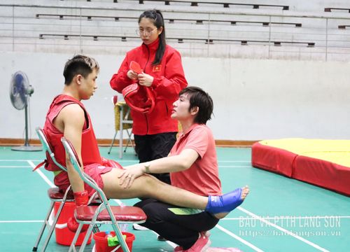 Trong thời gian nghỉ giữa các hiệp đấu, huấn luyện viên đóng vai trò điểm tựa quan trọng cho VĐV cả về thể lực lẫn tinh thần. Trong ảnh, huấn luyện viên đoàn Lạng Sơn đang hỗ trợ giãn cơ cho VĐV giúp họ thả lỏng cơ bắp, giảm áp lực sau những pha đối kháng căng thẳng. Xen lẫn đó là những lời động viên, chỉ đạo nhanh về chiến thuật, góp phần giúp VĐV ổn định tâm lý, lấy lại nhịp độ và sẵn sàng bước vào hiệp đấu tiếp theo với quyết tâm cao hơn.