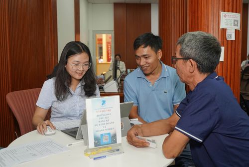 Cán bộ hỗ trợ người dân làm thủ tục đăng ký hộ kinh doanh và doanh nghiệp tại Trung tâm hành chính công phường Tam Bình, TP.HCM. Ảnh: THUẬN VĂN
