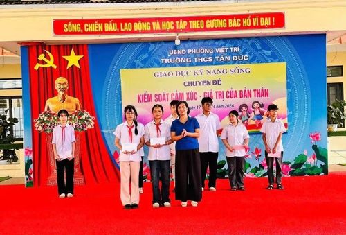 Bà Hoàng Thị Kim Liên - Hiệu trưởng Trường THCS Tân Đức trao thưởng cho học sinh.