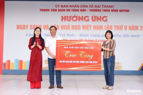 Đại diện Hội Nhà văn Việt Nam tặng 300 đầu sách cho thư viện Trường THCS Vĩnh Quỳnh. Ảnh: MD