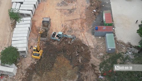 Tại công trường, nhiều máy xúc, máy cẩu cùng xe tải liên tục ra vào để vận chuyển đất đá, ống cống và vật liệu phục vụ thi công. Công nhân chia thành nhiều nhóm, khẩn trương đào rãnh, lắp đặt cống ngầm và gia cố mặt bằng nhằm đẩy nhanh tiến độ trước mùa mưa. Tiếng máy móc hoạt động liên hồi từ sáng đến tối khiến không khí khu vực luôn trong tình trạng nhộn nhịp, hối hả.