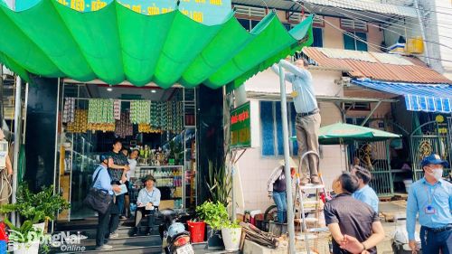 Lực lượng chức năng phường Bình Phước kiểm tra, xử lý trường hợp lấn chiếm vỉa hè trên đường Võ Văn Tần. Ảnh: Nhã Trâm