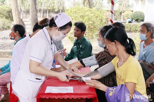 Nhân viên y tế đo huyết áp cho người dân tại chương trình. Ảnh: Như Tình
