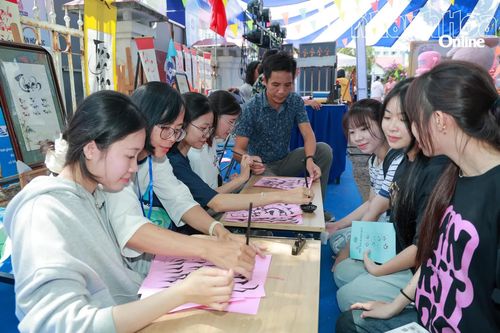 Các bạn trẻ được hướng dẫn cách viết thư pháp.