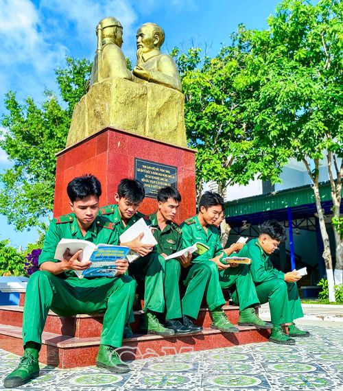 Cán bộ, chiến sĩ Đồn Biên phòng Hòn Khoai đọc sách bên tượng đài “Bác Hồ với chiến sĩ Biên phòng”.