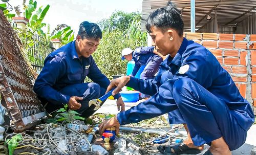 Nhân viên Trung tâm Nước sạch và Vệ sinh môi trường nông thôn tỉnh Cà Mau lắp đặt đồng hồ nước cho người dân xã Biển Bạch.