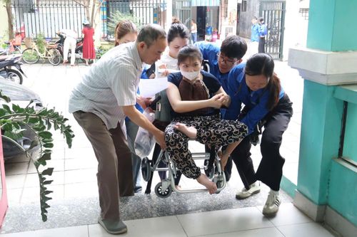 Lực lượng đoàn viên, thanh niên hỗ trợ người khuyết tật đến khám sức khỏe tại chương trình. Ảnh: QA