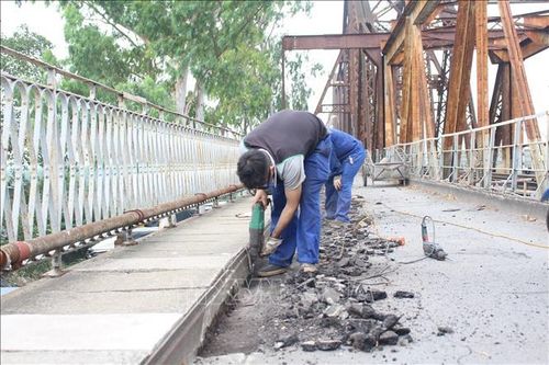 Công nhân bóc gỡ thảm nhựa cũ trên bề mặt đường.