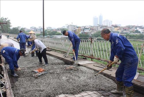Công nhân đổ bê tông trên mặt cầu phần đường bộ.