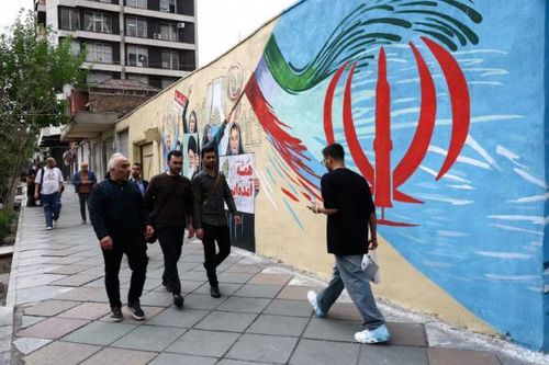 Người dân di chuyển trên một con phố tại thủ đô Tehran, Iran ngày 21/4. Ảnh Reuters.
